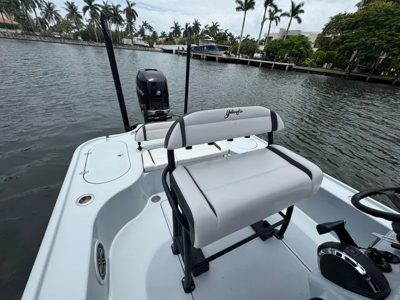 Slide: The Image of 2019 Yellowfin 24 Bay CE boat with seating, motor, and waterway view. - 16