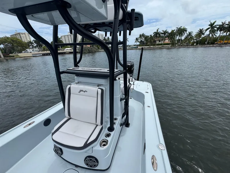 Slide: The Image of 2019 Yellowfin 24 Bay CE boat on calm water with palm trees in the background. - 18