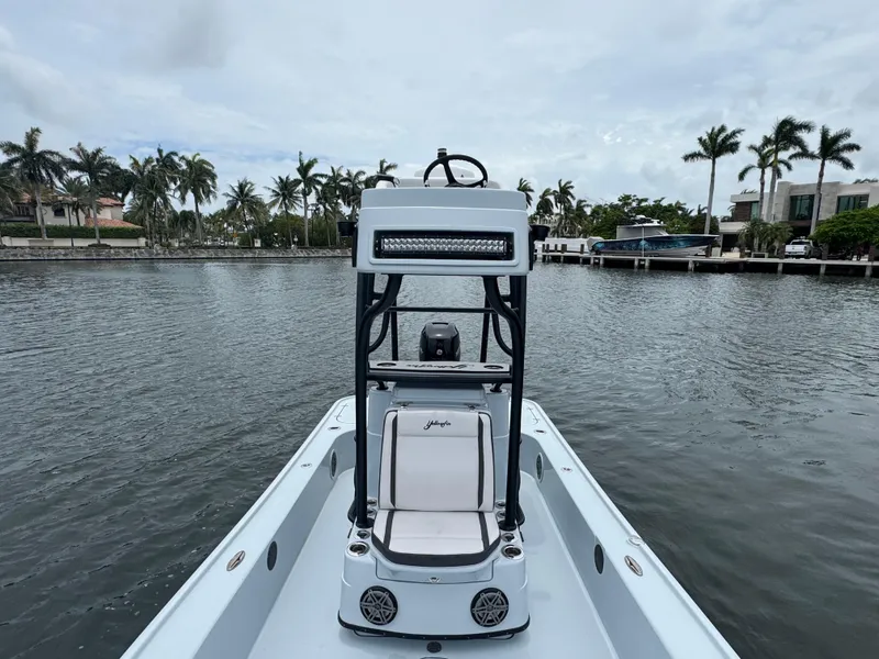 Slide: The Image of 2019 Yellowfin 24 Bay CE boat on calm water, surrounded by palm trees. - 21