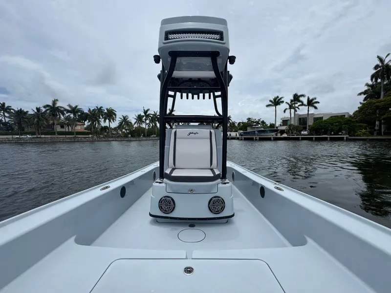 Slide: The Image of 2019 Yellowfin 24 Bay CE boat on calm water with palm trees in background. - 22