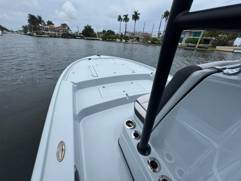 Slide: The Image of 2019 Yellowfin 24 Bay CE boat on calm water, showcasing sleek design and spacious deck. - 23