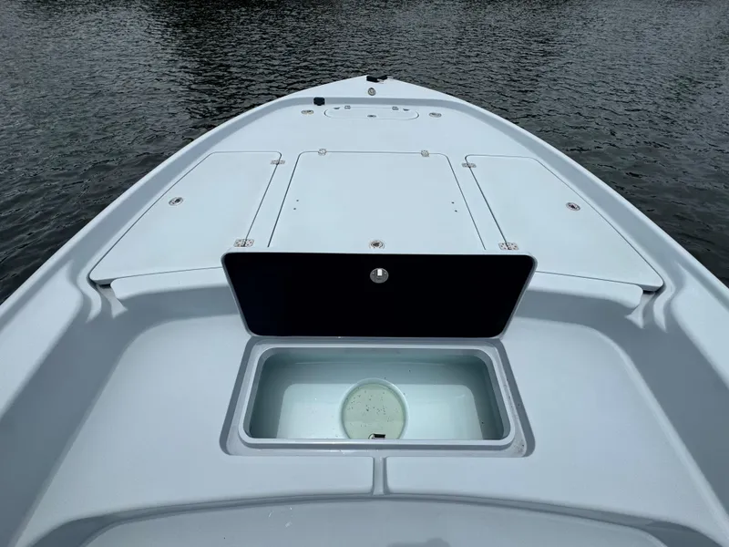 Slide: The Image of 2019 Yellowfin 24 Bay CE boat deck with storage compartments on calm water. - 26