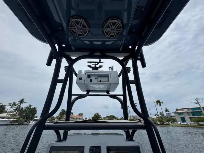 Slide: The Image of 2019 Yellowfin 24 Bay CE boat console with speakers, on a cloudy day. - 28