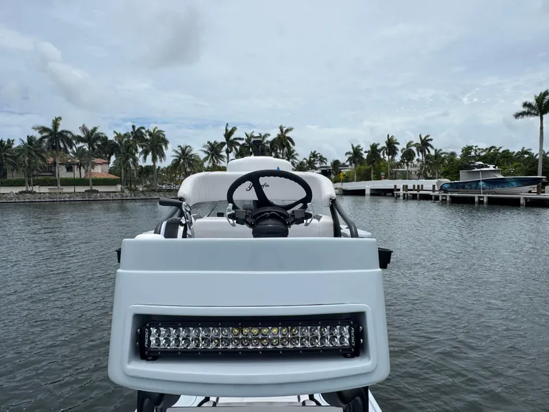 Slide: The Image of 2019 Yellowfin 24 Bay CE boat docked near palm trees and waterfront homes. - 31