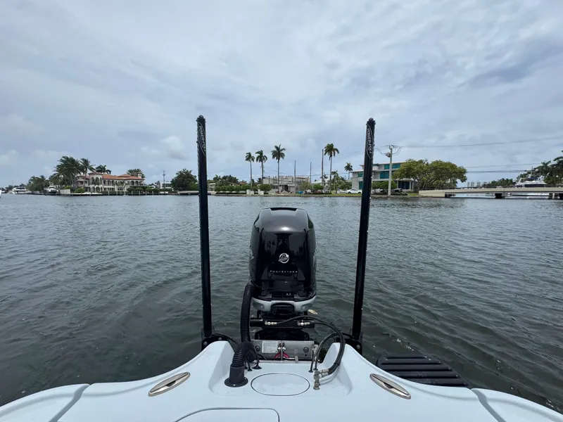 Slide: The Image of 2019 Yellowfin 24 Bay CE boat on water, scenic waterfront view with palm trees. - 32