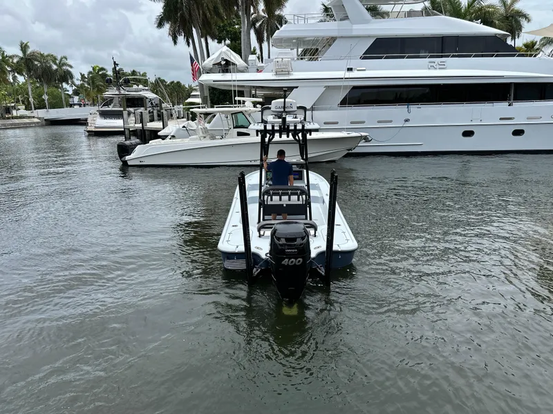Slide: The Image of 2019 Yellowfin 24 Bay CE boat navigating marina near luxury yachts. - 5