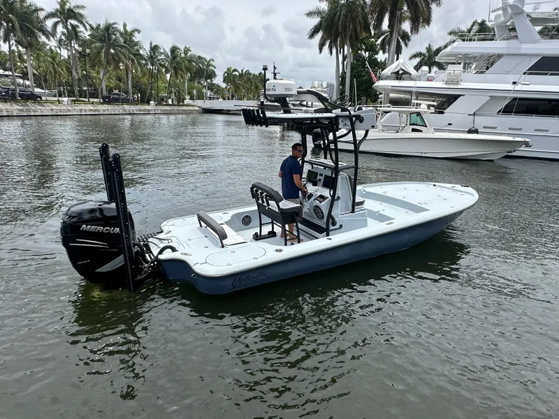 Slide: The Image of 2019 Yellowfin 24 Bay CE boat on water, with palm trees and yachts in the background. - 6