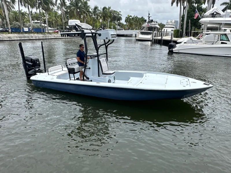 Slide: The Image of 2019 Yellowfin 24 Bay CE boat on water, surrounded by palm trees and yachts. - 7