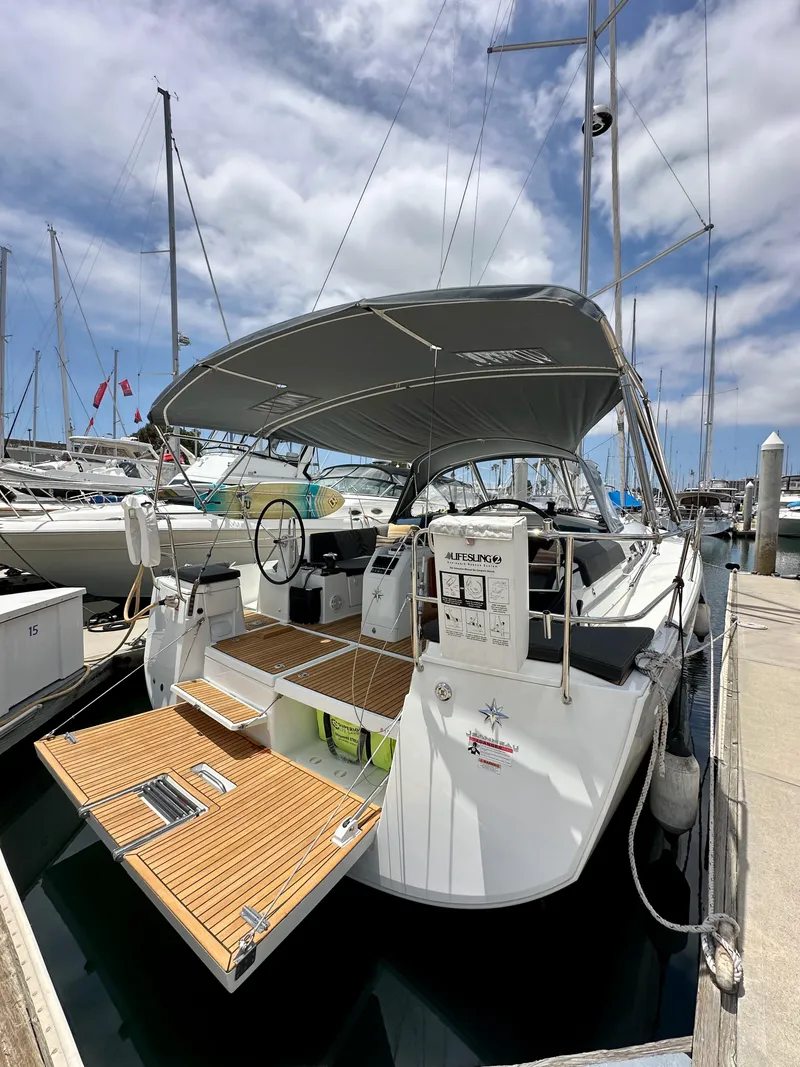 Slide: The Image of 2021 Jeanneau Sun Odyssey 440 sailboat docked at marina under cloudy sky. - 13
