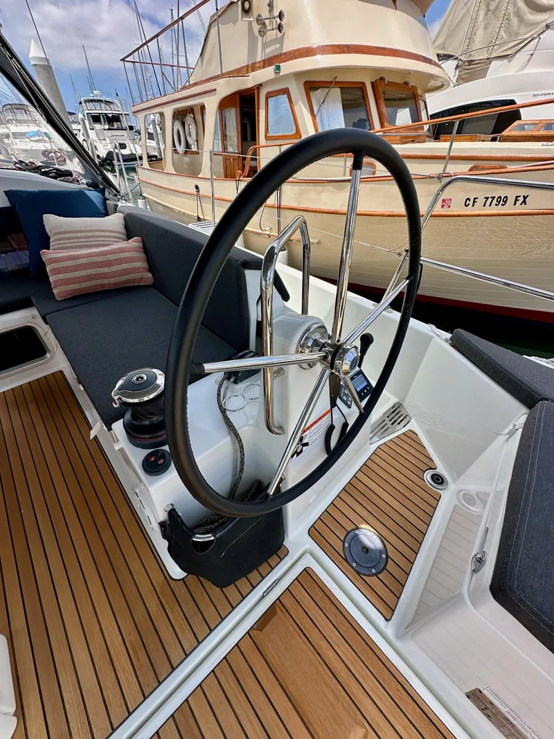 Slide: The Image of 2021 Jeanneau Sun Odyssey 440 yacht cockpit with steering wheel and teak flooring. - 24