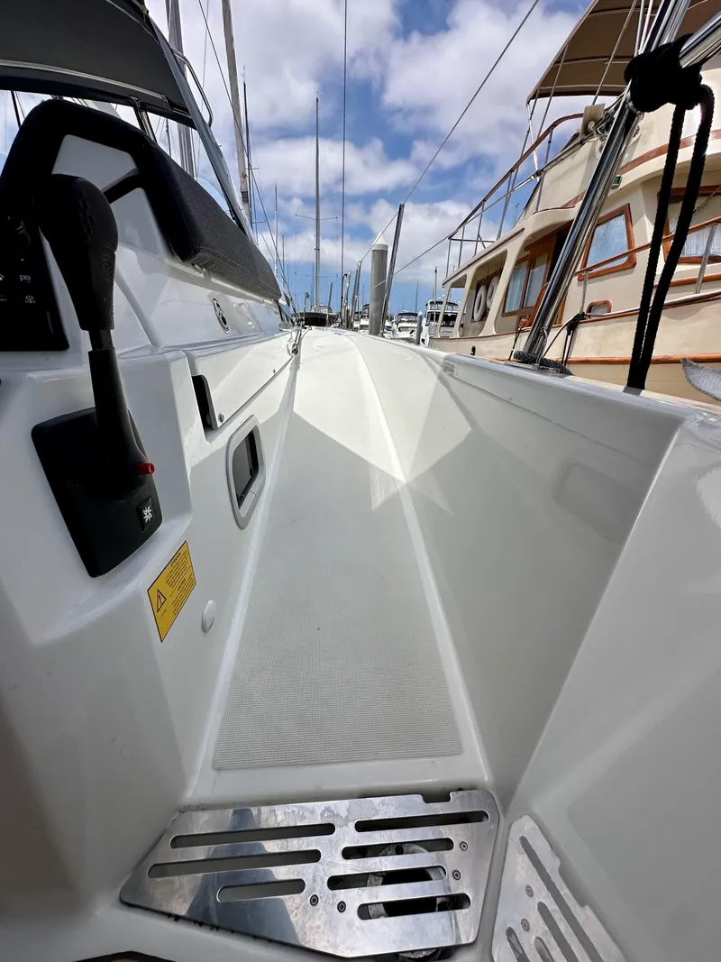 Slide: The Image of Jeanneau Sun Odyssey 440 sailboat deck, 2021 model, with clear skies and marina view. - 29