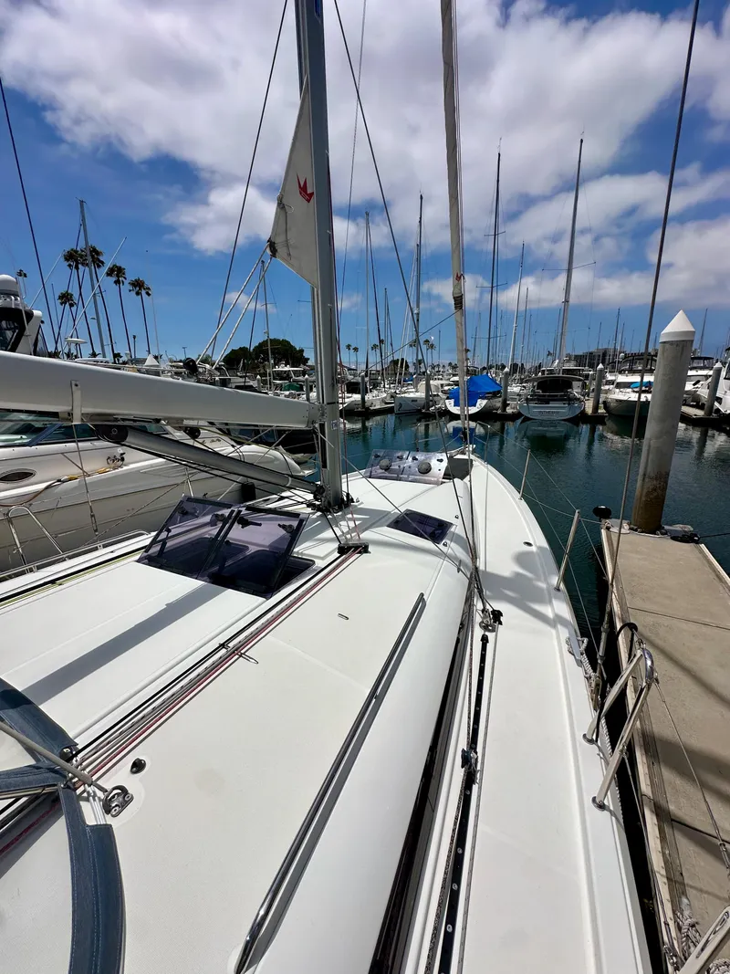 Slide: The Image of Sailboat Jeanneau Sun Odyssey 440, 2021 model, docked in a marina under a blue sky. - 32