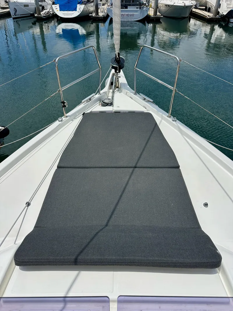 Slide: The Image of Jeanneau Sun Odyssey 440, 2021 model, deck view with sunbathing area in marina. - 34