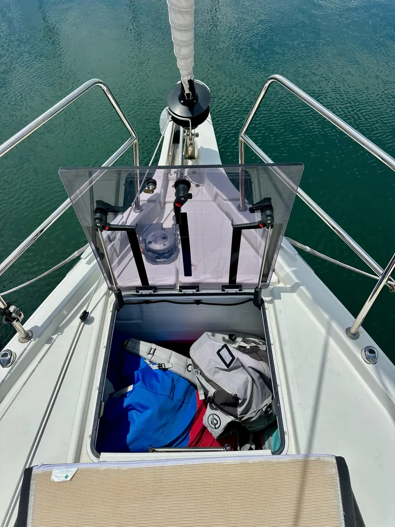 Slide: The Image of Open storage compartment on 2021 Jeanneau Sun Odyssey 440 sailboat, with bags and gear inside. - 35