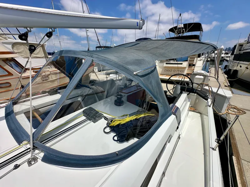 Slide: The Image of 2021 Jeanneau Sun Odyssey 440 sailboat docked, featuring a sleek canopy and organized deck. - 41