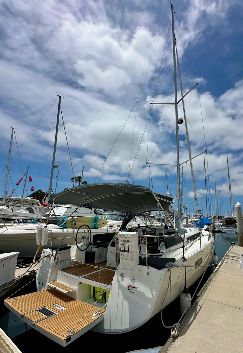 Slide: The Image of 2021 Jeanneau Sun Odyssey 440 sailboat docked at marina under cloudy sky. - 5