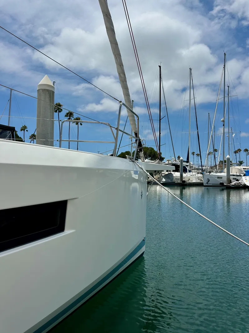 Slide: The Image of Jeanneau Sun Odyssey 440 yacht docked in marina, 2021 model, under blue sky. - 6