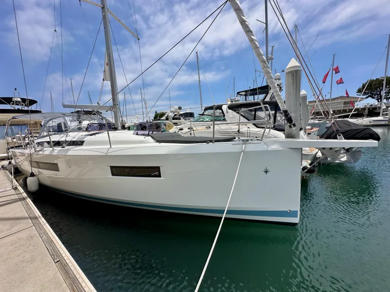 Slide: The Image of 2021 Jeanneau Sun Odyssey 440 sailboat docked at marina under blue sky. - 7