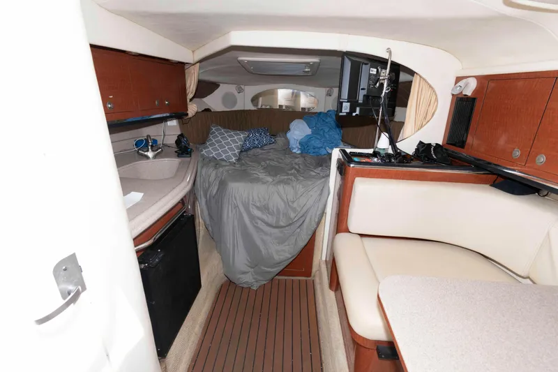 Slide: The Image of 2005 Sea Ray 290 Amberjack cabin interior with bed, kitchenette, and seating area. - 8