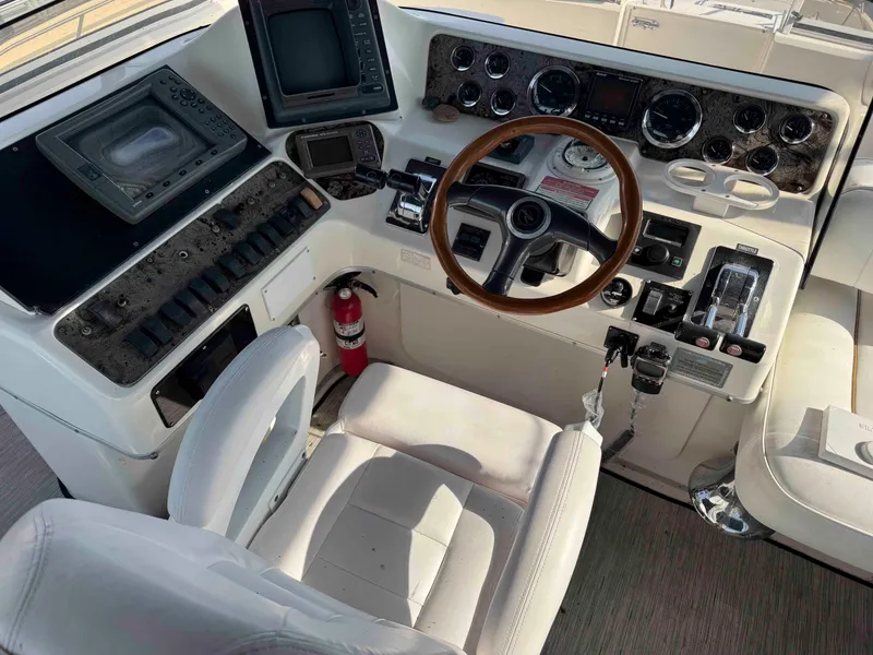 Slide: The Image of 1998 Sea Ray 440 Express Bridge helm with steering wheel and control panel. - 10
