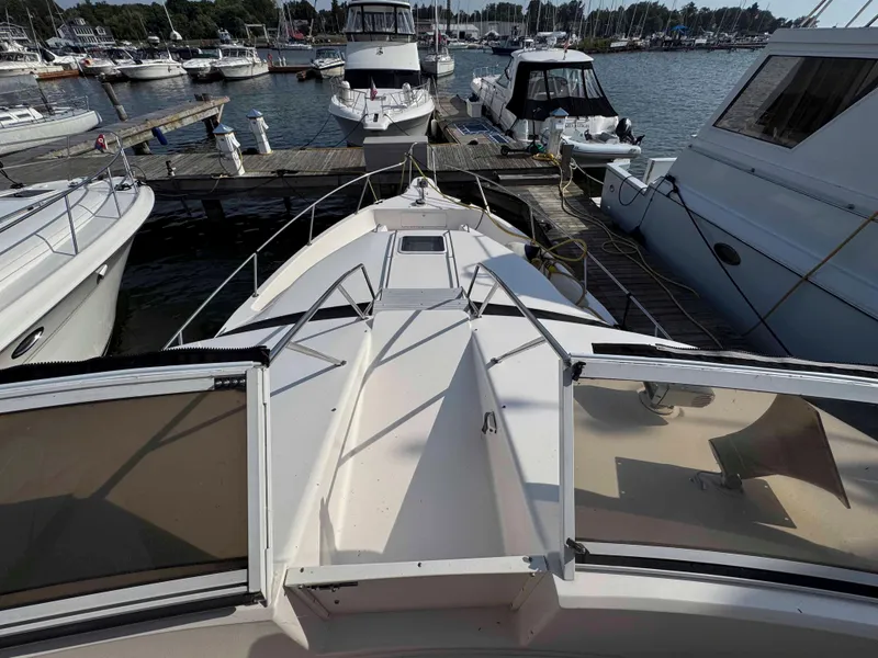 Slide: The Image of 1998 Sea Ray 440 Express Bridge docked at a marina, surrounded by other boats. - 14