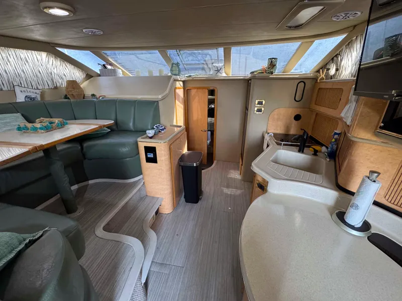 Slide: The Image of Interior of 1998 Sea Ray 440 Express Bridge yacht with modern seating and kitchenette. - 16
