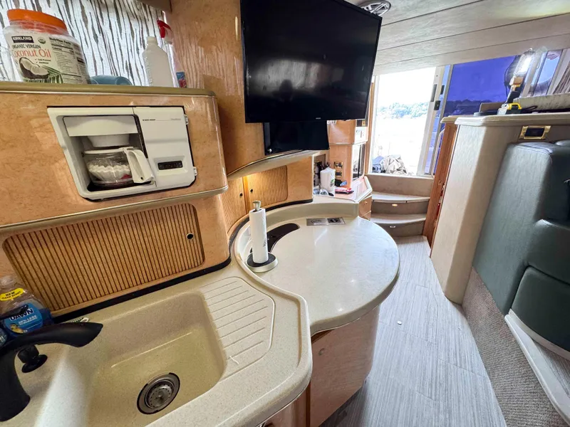 Slide: The Image of Interior of 1998 Sea Ray 440 Express Bridge yacht with kitchenette and TV. - 19