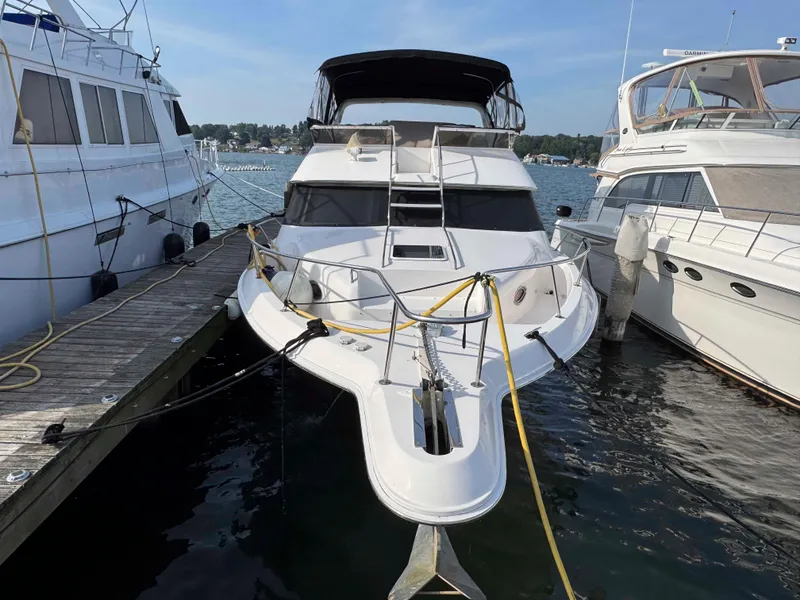 Slide: The Image of 1998 Sea Ray 440 Express Bridge yacht docked at marina, surrounded by other boats. - 2