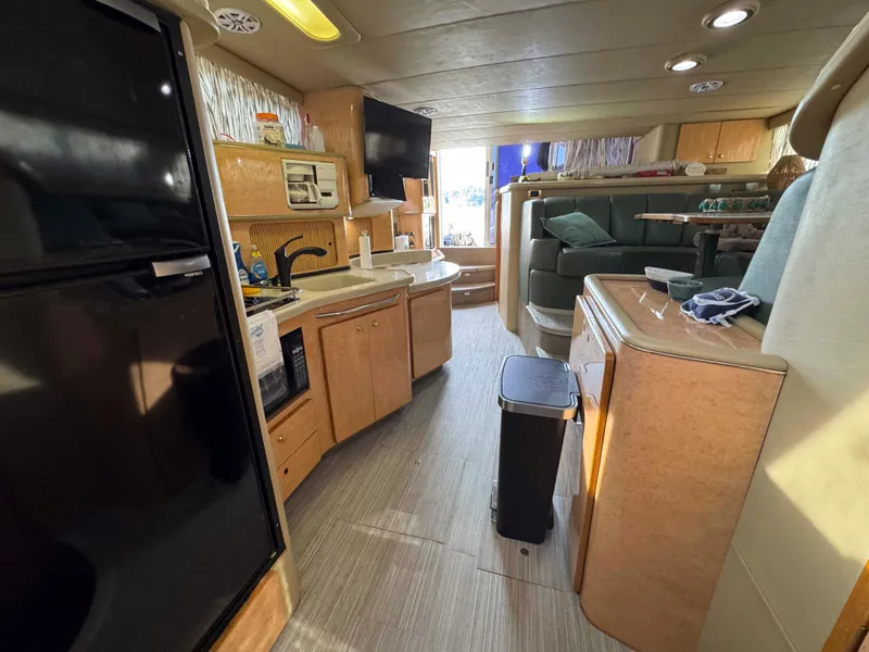 Slide: The Image of Interior of 1998 Sea Ray 440 Express Bridge yacht with kitchen and seating area. - 21
