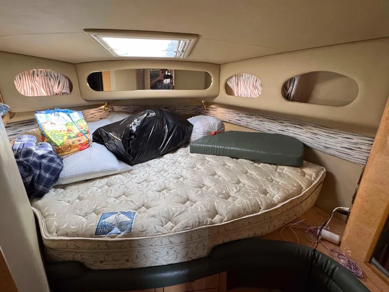 Slide: The Image of 1998 Sea Ray 440 Express Bridge cabin interior with mattress and storage items. - 24