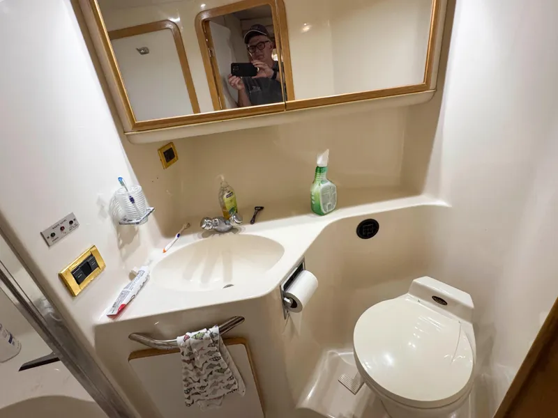 Slide: The Image of Bathroom interior of 1998 Sea Ray 440 Express Bridge yacht, featuring sink and toilet. - 25