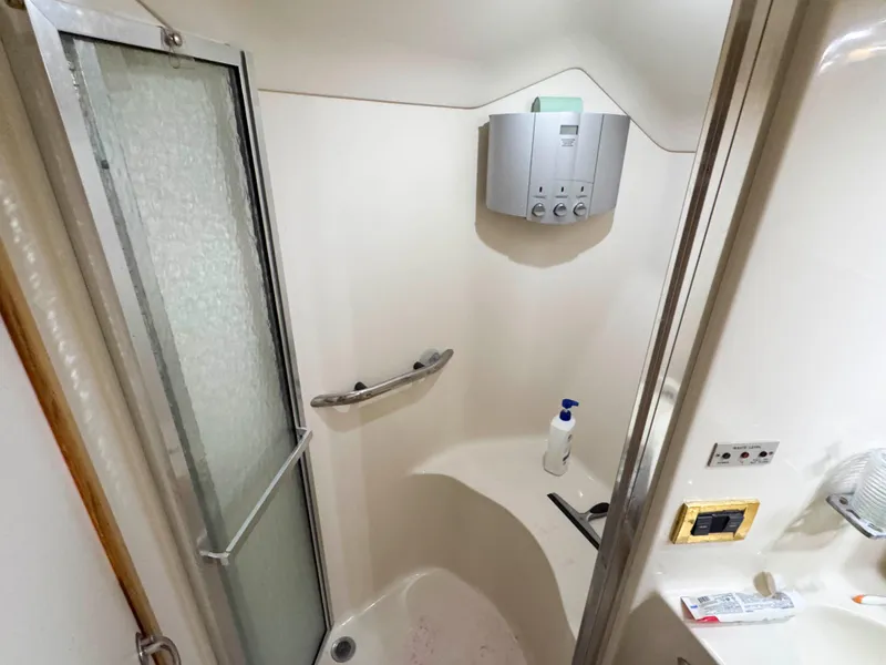 Slide: The Image of 1998 Sea Ray 440 Express Bridge bathroom with shower, soap dispenser, and modern fixtures. - 26