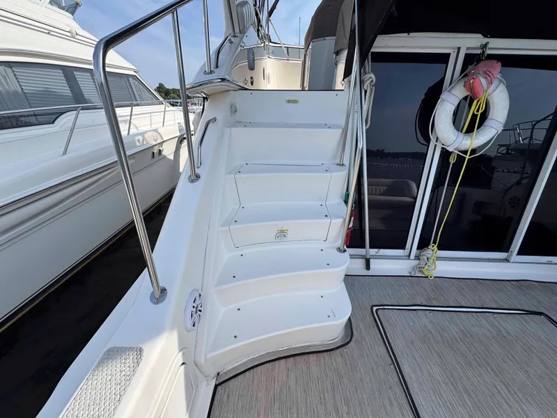 Slide: The Image of 1998 Sea Ray 440 Express Bridge yacht with stairs and life preserver on deck. - 4