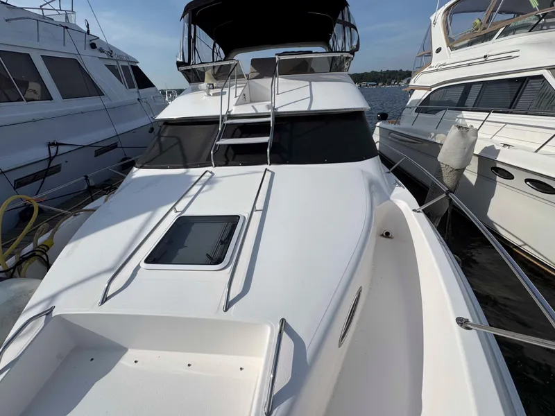 Slide: The Image of 1998 Sea Ray 440 Express Bridge yacht docked between other boats. - 8