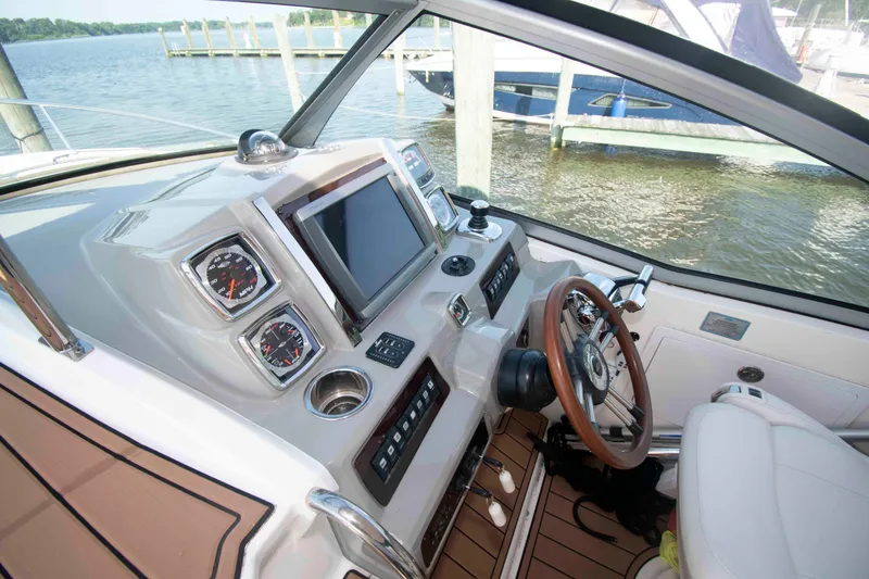 Slide: The Image of 2014 Chaparral 310 Signature boat helm with modern controls and wood-accented steering wheel. - 10