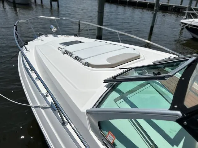 Slide: The Image of 2014 Chaparral 310 Signature boat docked, featuring sleek design and open deck. - 14