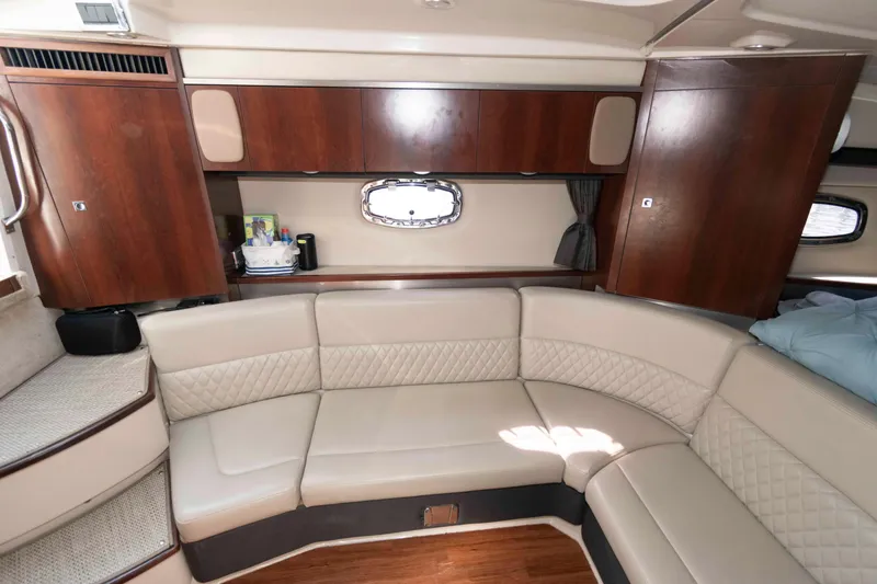 Slide: The Image of 2014 Chaparral 310 Signature yacht interior with beige seating and wooden cabinetry. - 16