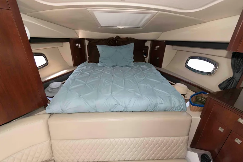 Slide: The Image of Luxurious cabin interior of 2014 Chaparral 310 Signature with cozy bed and elegant wood finish. - 17