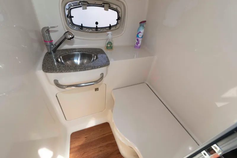 Slide: The Image of 2014 Chaparral 310 Signature boat bathroom with sink, window, and storage. - 24