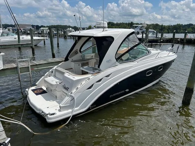 Slide: The Image of 2014 Chaparral 310 Signature boat docked at a marina under a partly cloudy sky. - 3