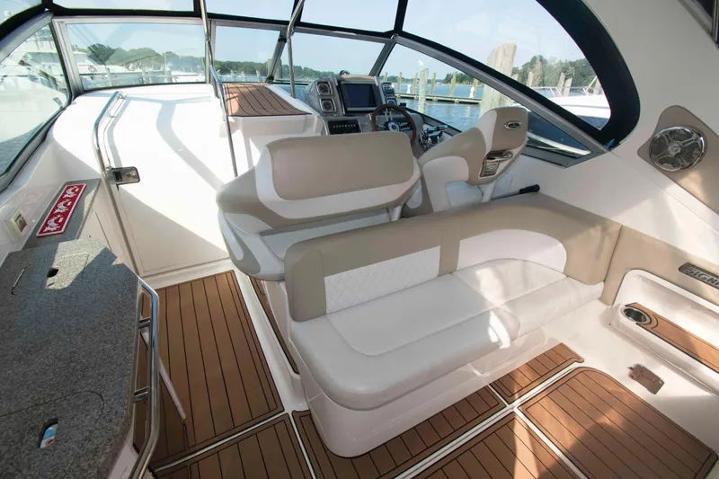 Slide: The Image of 2014 Chaparral 310 Signature boat interior with beige seating and wood flooring. - 5