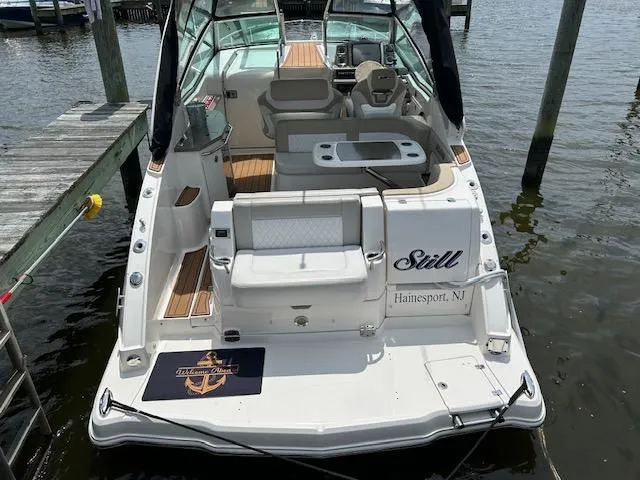 Slide: The Image of 2014 Chaparral 310 Signature boat docked, featuring spacious seating and elegant design. - 6