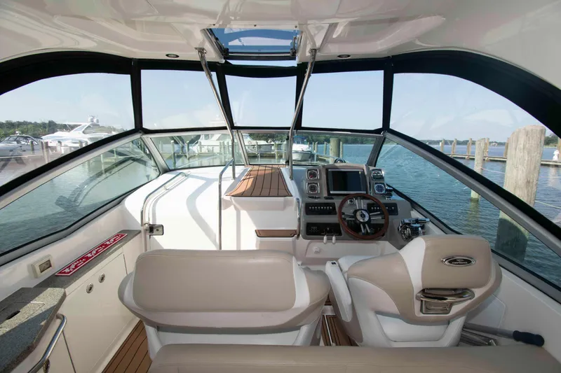 Slide: The Image of 2014 Chaparral 310 Signature boat interior with helm, steering wheel, and navigation equipment. - 7