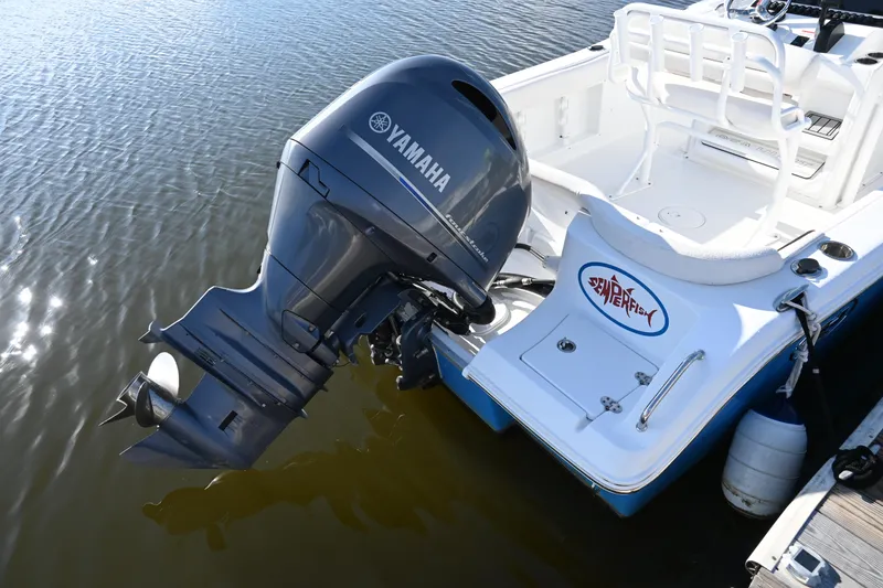 Slide: The Image of 2021 Sea Hunt Ultra 219 boat with Yamaha outboard motor, docked on calm water. - 13