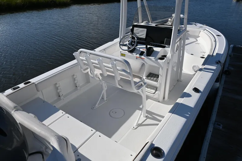 Slide: The Image of 2021 Sea Hunt Ultra 219 boat interior with console and seating, docked on calm water. - 14