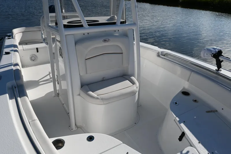 Slide: The Image of 2021 Sea Hunt Ultra 219 boat interior with seating and console, on calm water. - 29
