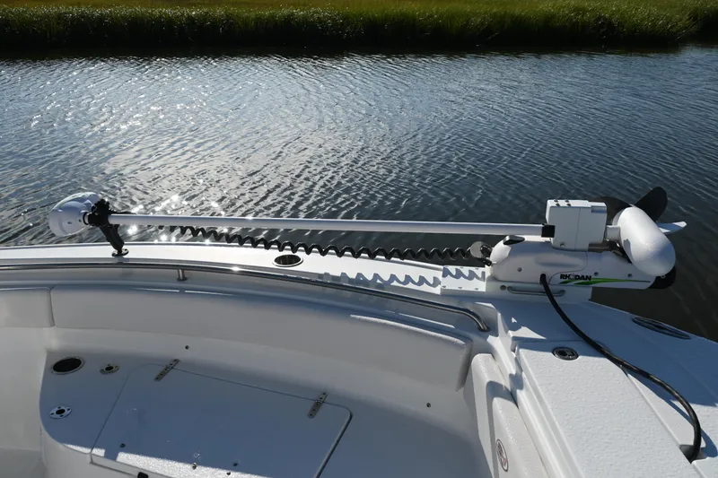 Slide: The Image of 2021 Sea Hunt Ultra 219 boat with trolling motor on calm water. - 34