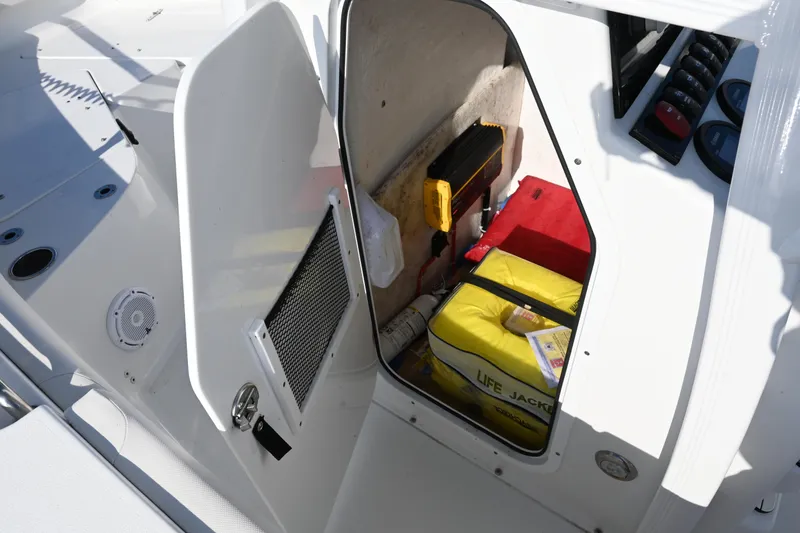 Slide: The Image of 2021 Sea Hunt Ultra 219 boat storage compartment with life jackets and safety equipment. - 37