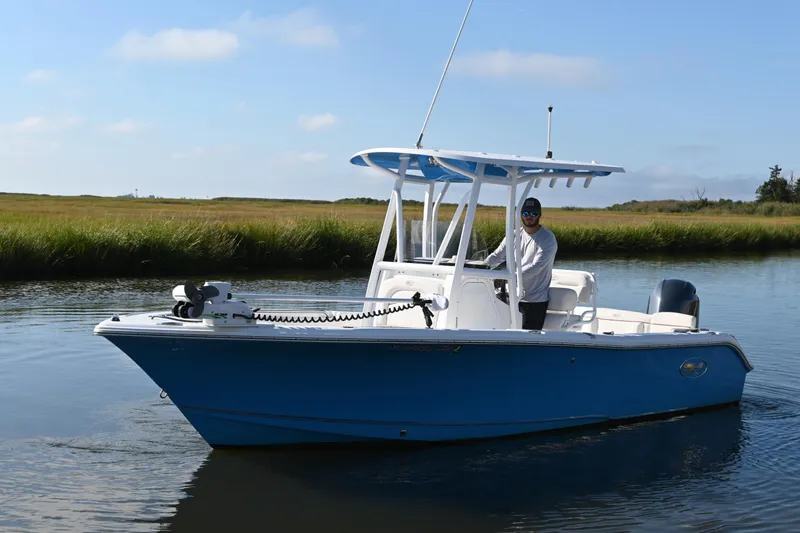 Slide: The Image of 2021 Sea Hunt Ultra 219 boat on calm water, featuring a sleek blue hull. - 5