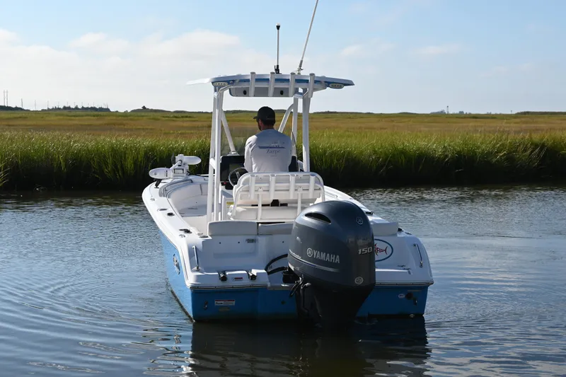 Slide: The Image of 2021 Sea Hunt Ultra 219 boat with Yamaha engine navigating a calm waterway. - 9